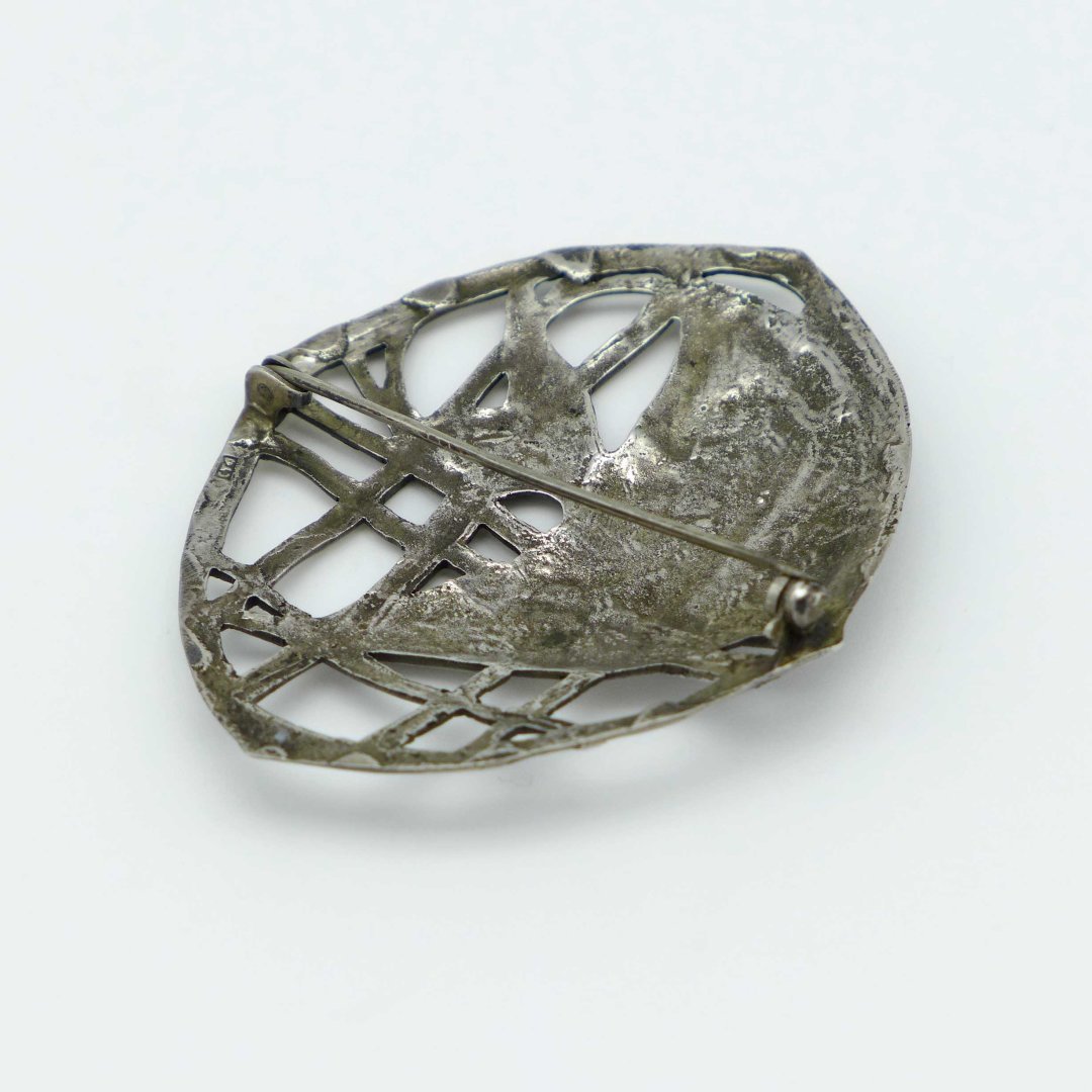 Silver brooch with fish in the kelp