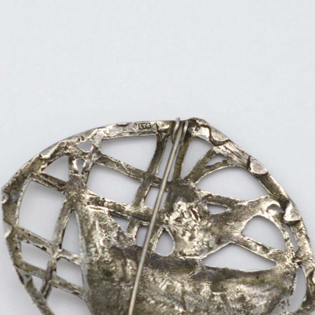 Silver brooch with fish in the kelp