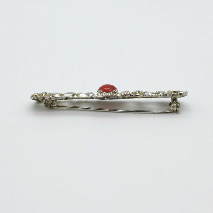 Elongated silver brooch with coral