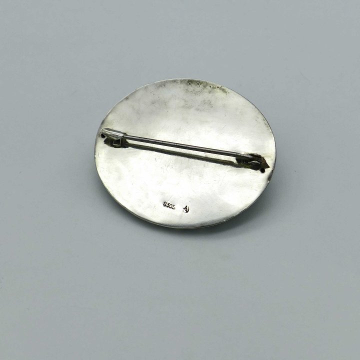 Geared silver brooch with green paste
