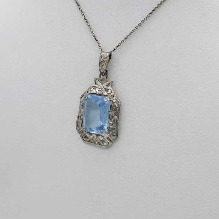 Silver pendant with flowers and aquamarine colored stone