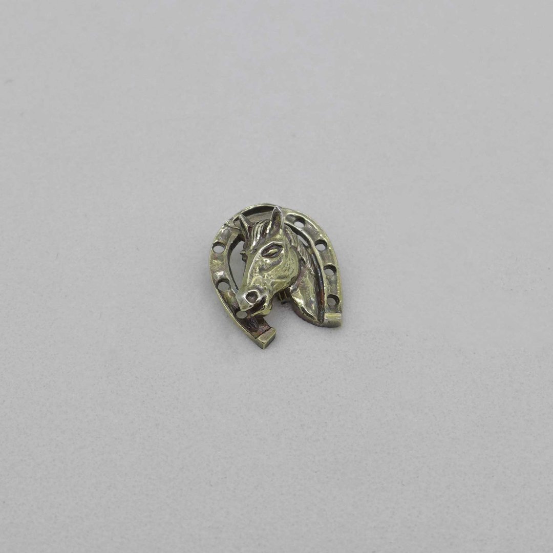 Silver pin with horseshoe and horse head