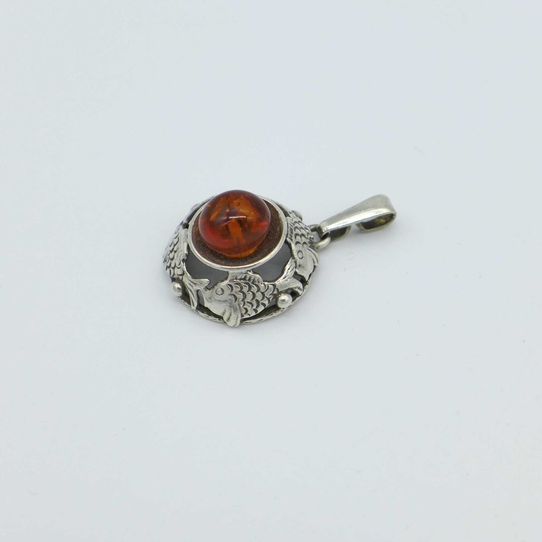 Fischland - Round pendant with amber and fish motifshland - ring with amber and fish motifs.