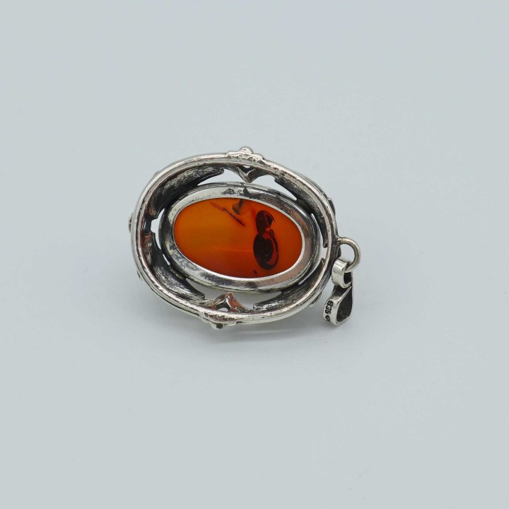 Fischland - Oval pendant with amber cabochon and fish motifs.