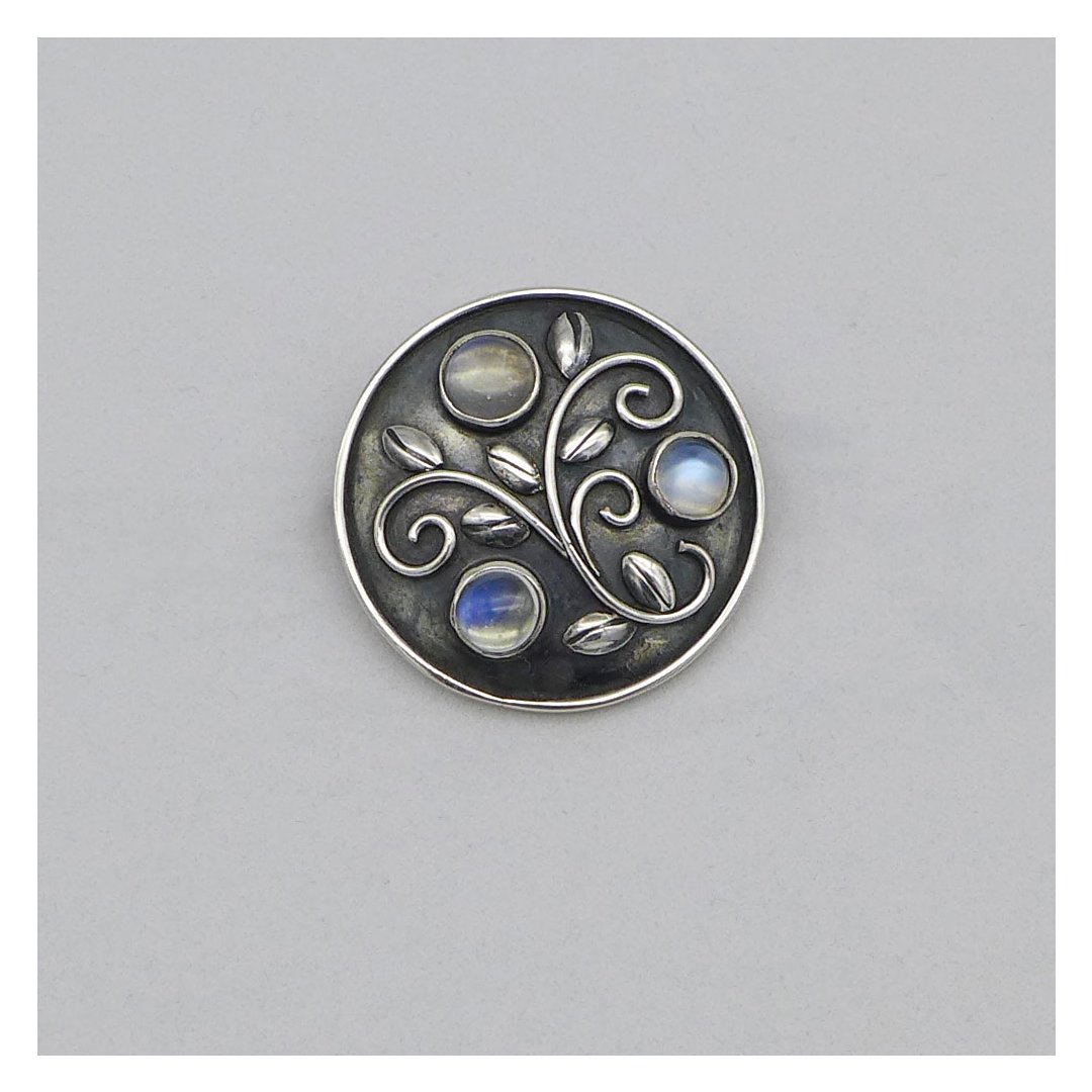 Round silver brooch with moonstones