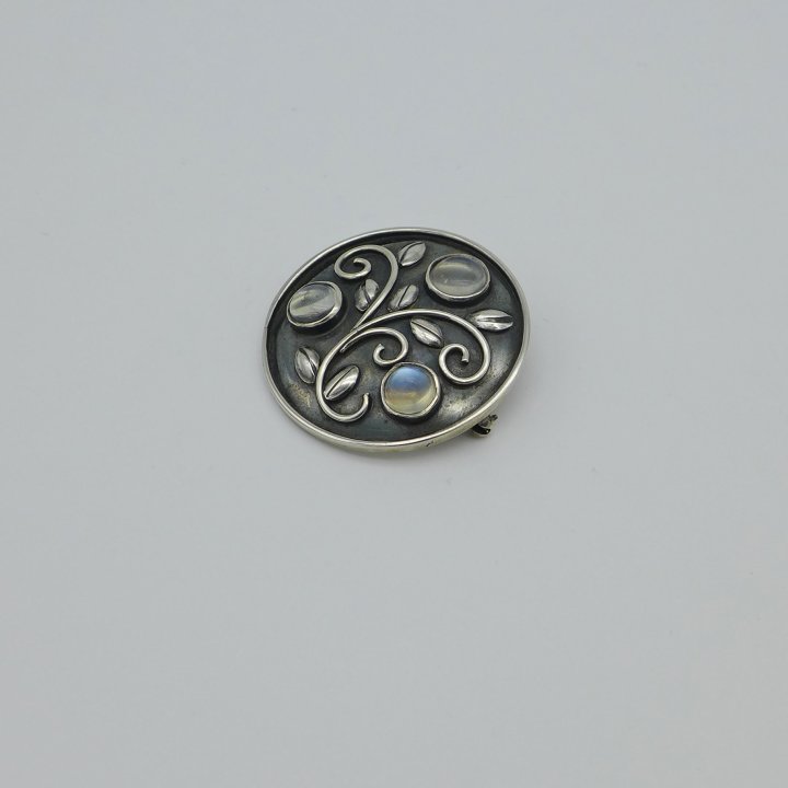 Round silver brooch with moonstones