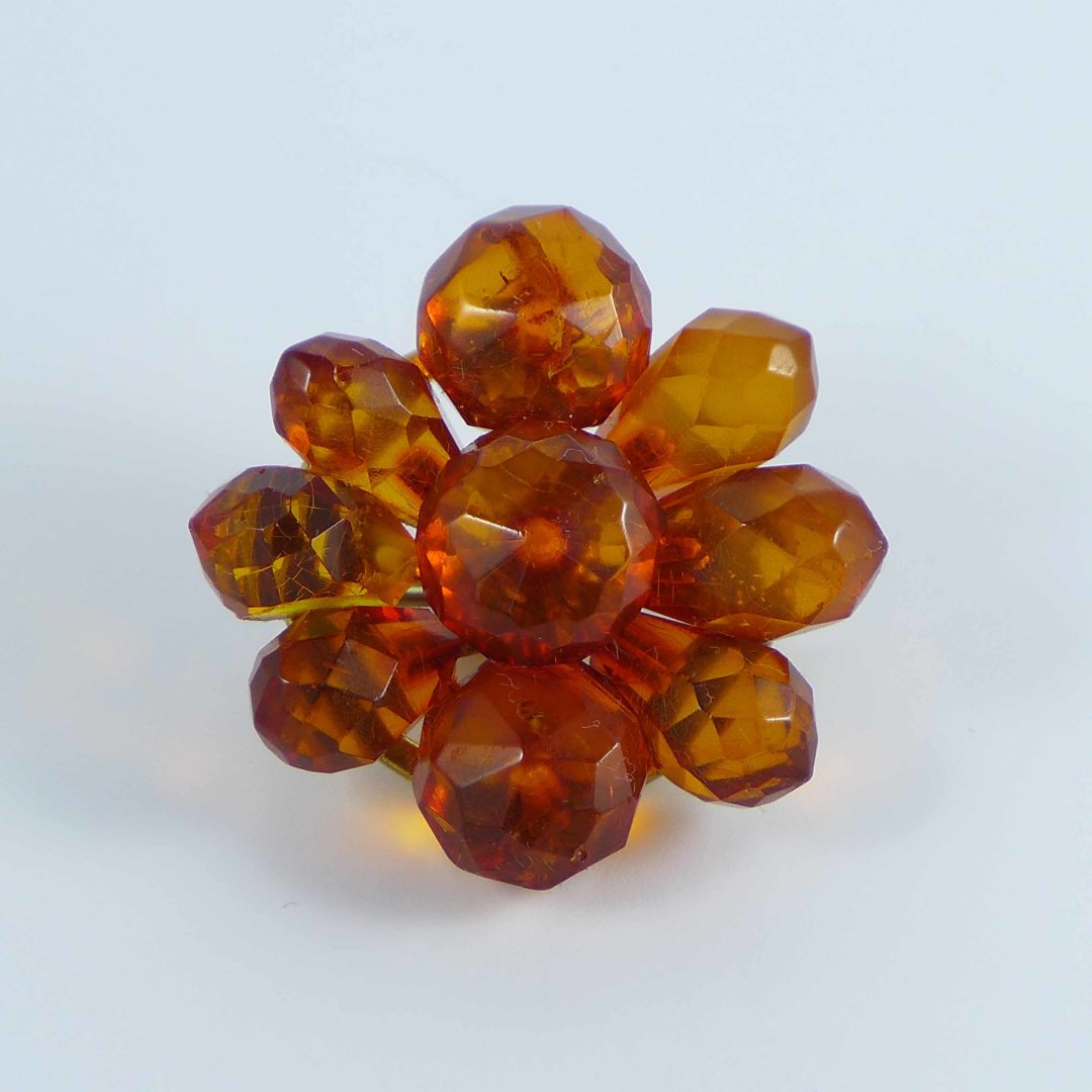Flower shaped brooch made of faceted amber stones