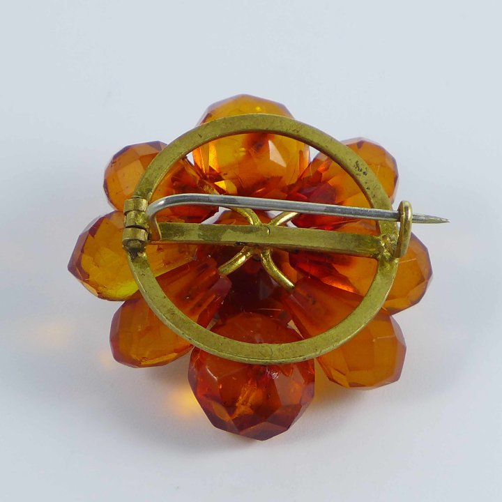 Flower shaped brooch made of faceted amber stones