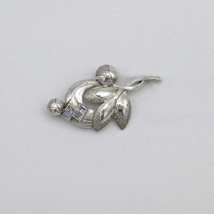Floral silver pin with light blue stones